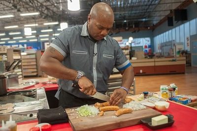 Contestant Aaron McCargo Jr. prepares his dish, as seen on Guy's Grocery Games, Season 9.